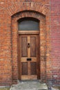 Heavy wooden door set in ancient brick wall with arched transom window near Dublin Ireland