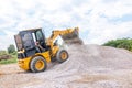 Heavy yellow bulldozer on construction. Wheel loader machine unloading rocks