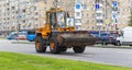 A heavy yellow road excavator on the road in the city. Moscow, Russia