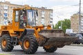 A heavy yellow road excavator on the road in the city. Moscow, Russia