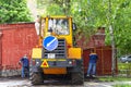 A heavy yellow road excavator on the road in the city. Moscow, Russia