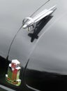 Detail of hood ornaments and badge on an old black british standard 10 automobile