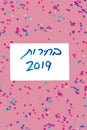 Hebrew text :Elections 2019 on voting paper over pink with colorful confetti background. Royalty Free Stock Photo