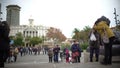 Hectic life in European city downtown, Asian tourists taking photo of sculpture