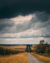 A country road heading off into the distance under a very stormy sky. Royalty Free Stock Photo