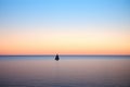 heeling sailboat silhouette on horizon line at dusk