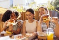 heerful happy female friends of different nationalities snacking on burgers and pizza outdoors and having fun together Royalty Free Stock Photo