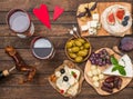 ÃÂ¡heese board with grapes, nuts, fig, dates, olives, wine on rustic wooden background. Top view. Gourmet appetizer for romantic