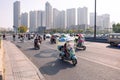 People on electric bicycle with colourful windshield on crossroad, Hefei, China.