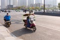 People on electric bicycle with colourful windshield on crossroad, Hefei, China.