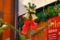 Two golden bells and red ribbon tied around pine tree as part of decoration on traditional Christmas market in Heidelberg city cen Royalty Free Stock Photo