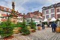 `Winter woods` with multiple fir trees standing around fountain with Madonna statue at square called `Kornmarkt` as part of tradit