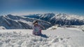 Heiligenblut - A girl siting on snow and admiring the view in front of her