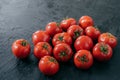 Heilroom fresh red tomatoes with green leaves, water drops, isolated over dark background. Delicious ripe vegetables harvested Royalty Free Stock Photo