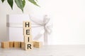 HEIR word made with building blocks on the table next to a flower and a gift box