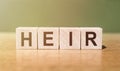 Heir Word Written In Wooden Cubes on a green-brown background