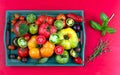 HeirloomTomates old whole and sliced in a green tray placed on red