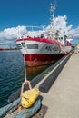 Hel, Poland - 08.01.2021: Vertical wide shot of red and white fishing boat tied to pier on a beautiful sunny summer day Royalty Free Stock Photo