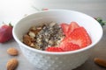 Helathy vegan oatmeal porridge with strawberries, chia seeds and sliced almonds