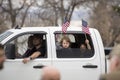 Helena, Montana - April 19, 2020: Children girls holding and waving American flag from a vehicle at the protest at the Capitol to
