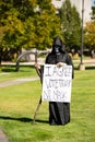 Helena, Montana / September 11, 2020: Counter protester at Trump freedom rally holding sign, vote Trump, no mask, mocking