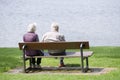 Helensburgh, Dunbartonshire / Scotland - June 22nd 2019: Retired old senior couple sat on park bench at sea coast