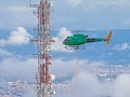 Helicopter approaching a communications antenna Royalty Free Stock Photo
