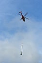 Helicopter as a flying crane transporting a pipe Royalty Free Stock Photo