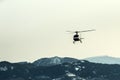 The helicopter climbing in front of the high snowy mountains