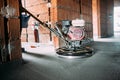 Helicopter concrete floor finishing on construction site. Construction worker finishing concrete screed with power trowel machine