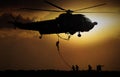 Helicopter dropping soldier during sunset Royalty Free Stock Photo