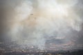 Helicopter flying in heavy smoke over rural area fighting wildfire