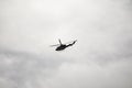 .a helicopter flying high in a cloudy sky Royalty Free Stock Photo