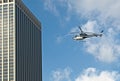 Helicopter flying next to skyscraper