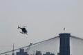 A helicopter flying over the Brooklyn Bridge