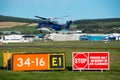 A Helicopter hovering behind airport signs and markings Royalty Free Stock Photo