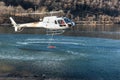The helicopter load water from Lake Ghirla to extinguish the mountain flames in Valganna, Italy.