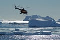 Helicopter over Antarctic icebergs