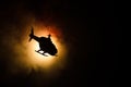 Helicopter over fire sunset horizon. War concept. Military scene of flying helicopter fire backgroung effect. Decoration Royalty Free Stock Photo