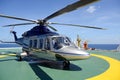 The helicopter park on oil rig platform to pick up worker with b