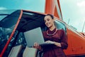 Beaming good-looking businesswoman in red shirt and bulky jewelry