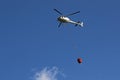 Helicopter picking up water during fire fighting operations