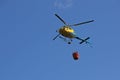 Helicopter picking up water during fire fighting operations