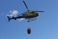 Helicopter picking up water during fire fighting operations