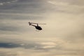 Helicopter silhouette against clouds