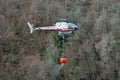 Helicopter transporting a bucket full of water Royalty Free Stock Photo