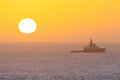 Heligoland, Germany - 02.26.2022: Small Nordic boat sailing in the North sea with a rising sun on the horizon. Royalty Free Stock Photo