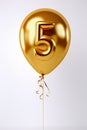 Helium golden balloon shape number five, 5. Isolated on white