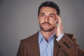 Hell come up with a solution. Studio shot of a man deep in thought against a gray background.