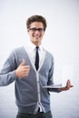 Hell fix your tablet in no time. A young nerd working on his laptop while giving you the thumbs up. Royalty Free Stock Photo